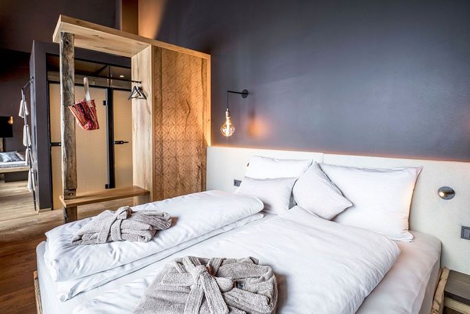 Blick vom Bett mit Altholzdetails auf den Wohnraum